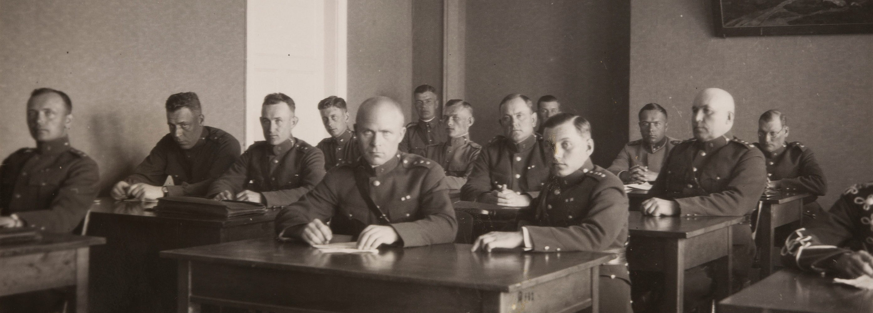 Sõjakooli kadetid istumas klassis laua taga.