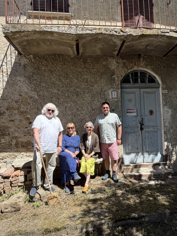 Grupp inimesi poseerimas maja taustal.